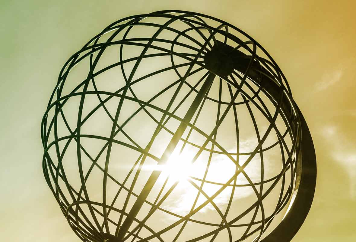 A big globe with sunlight in the background sipping through the globe